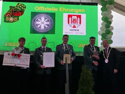 Bürgermeister Rainer Weber übergibt den Ehrenteller der Gemeinde Uedem an vier Vertreter*innen der Schützenbruderschaft St. Hubertus Uedemerbruch