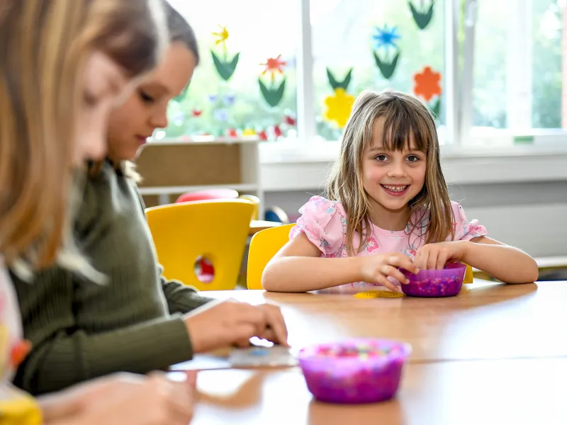 Kinder sitzen an einem Tisch und basteln 